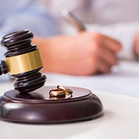 Mano firmando y mazo de abogados